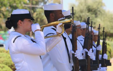 At Naval Air Station Lemoore a Navy bugler plays taps as the rifle team stands at attention commemorating The Battle of Midway.